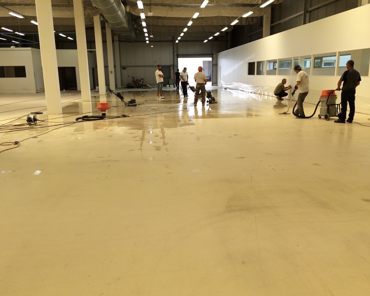 Du personnel Dr. Schutz est en train de décaper et nettoyer un sol ESD à rénover