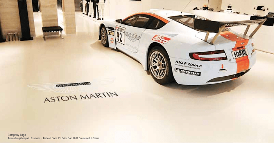 Exemple de logo incrusté dans le sol d'une salle d'exposition chez un concessionnaire Aston Martin
